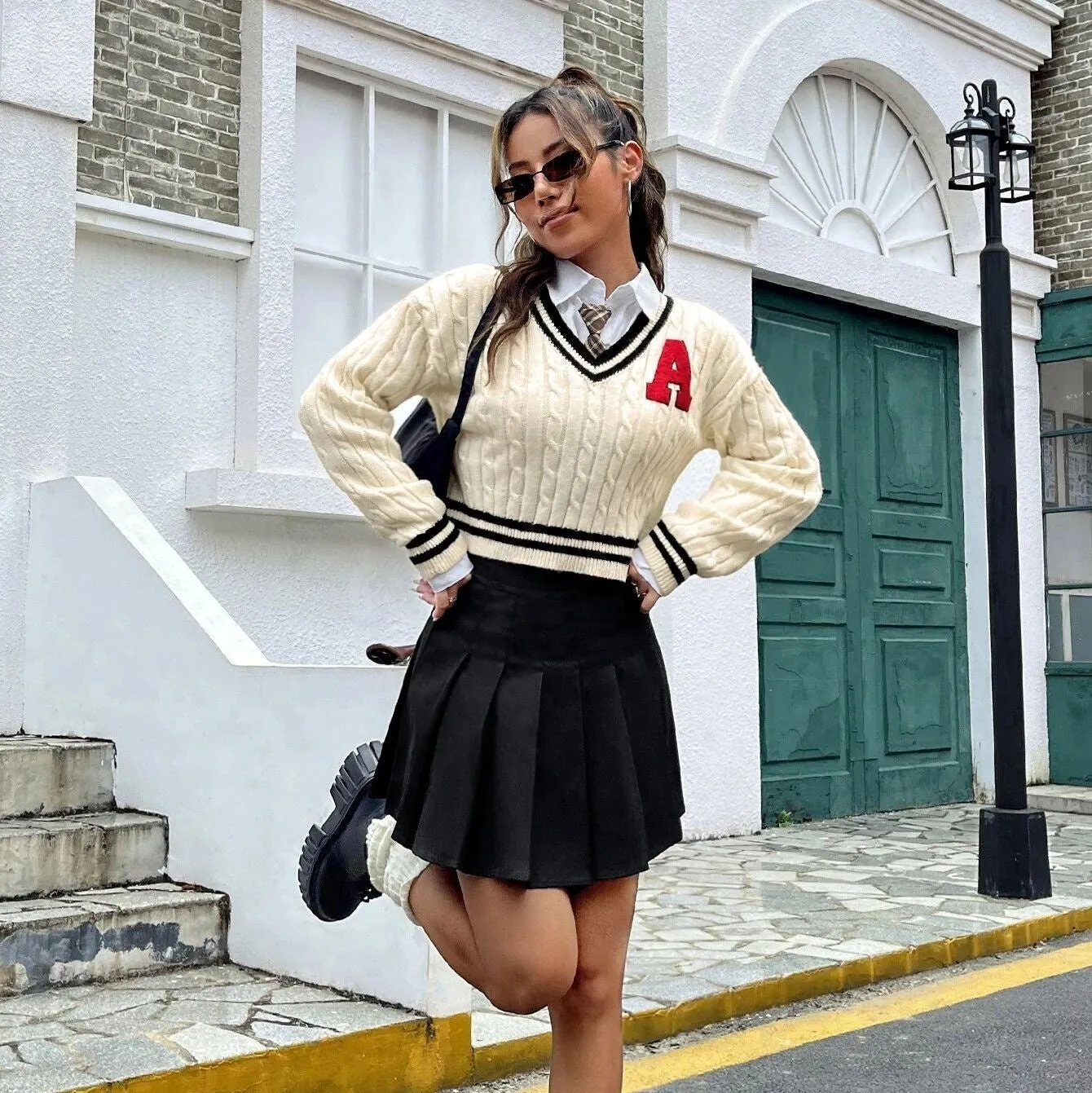 V-neck creamy white knitted shirt with slim stripes and patch detail on model