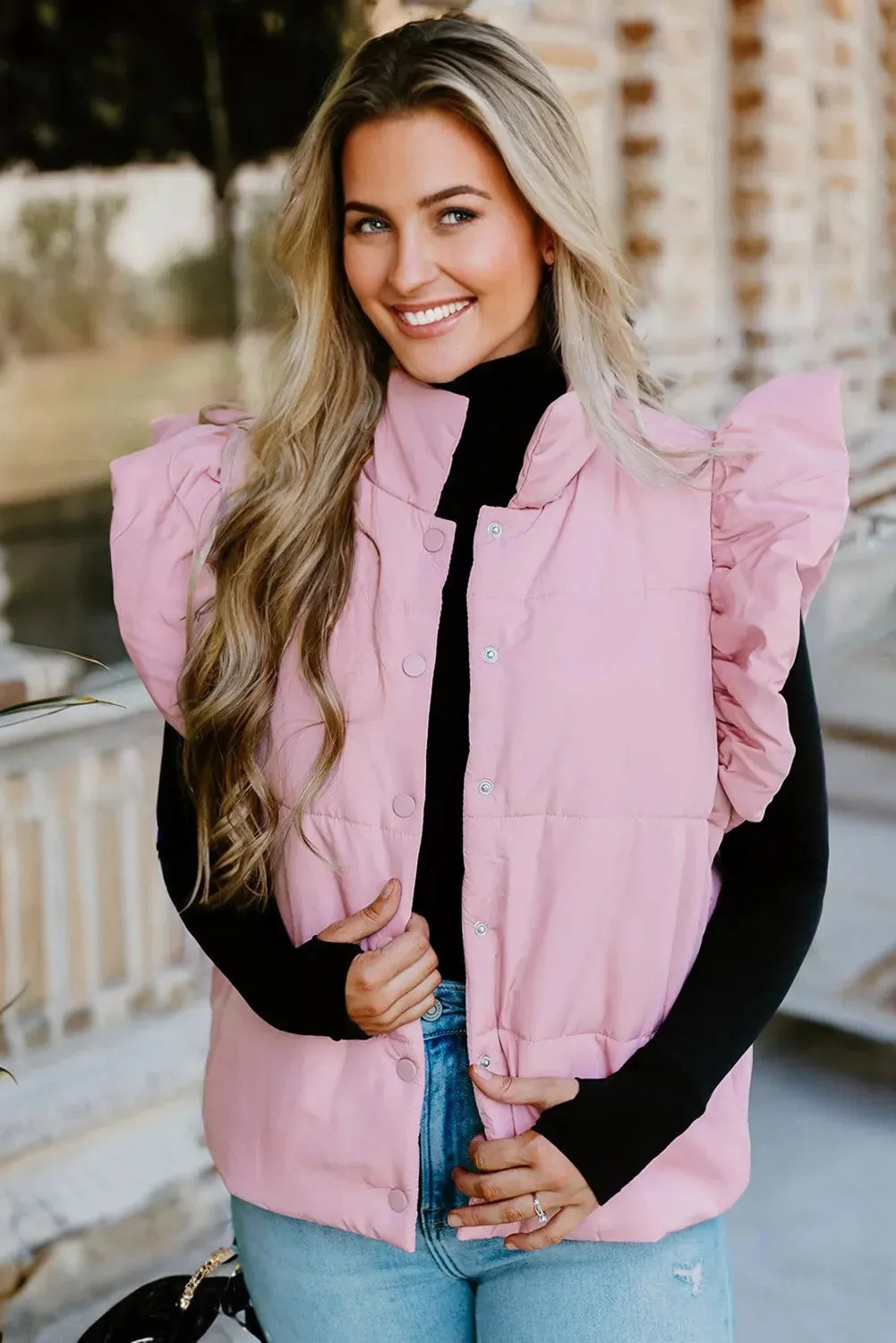 Pink polyester puffer vest with stand neck, flutter sleeves, and snap buttons – front view