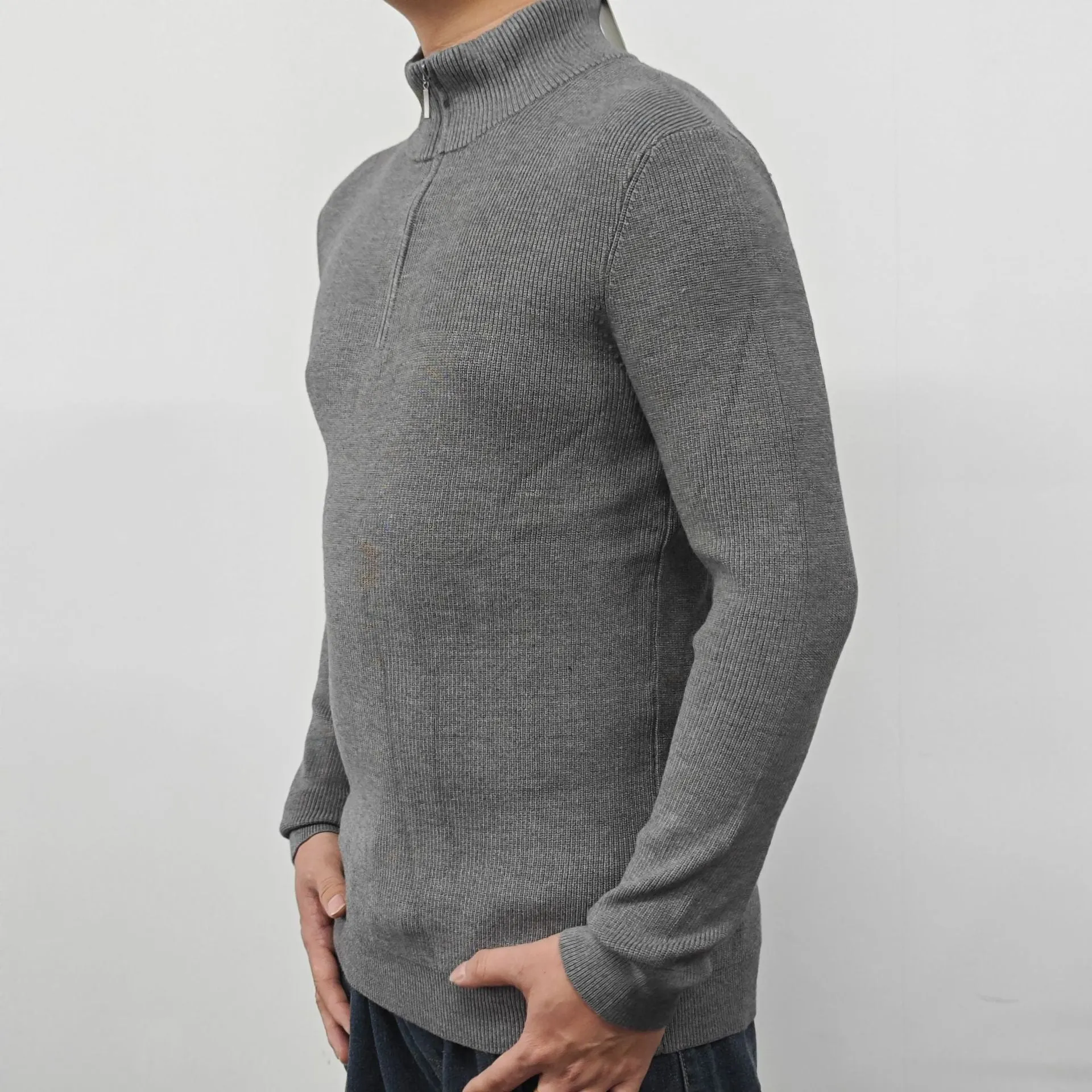 Men's black half-turtleneck zip sweater on a hanger, showing long sleeves and zip front detail.