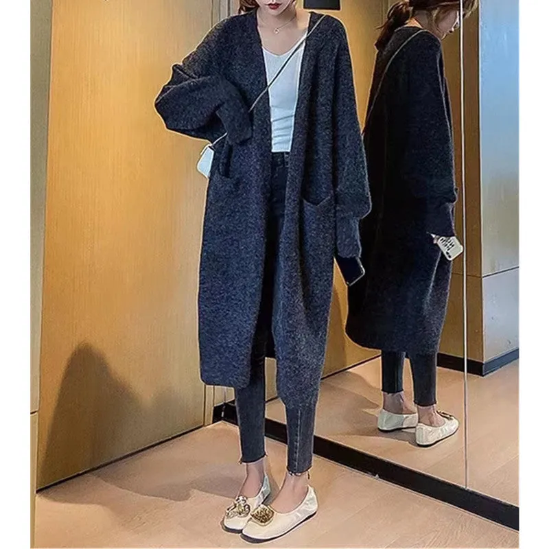 Women loose mid-length knitted cardigan in solid colour with long sleeves and pockets.