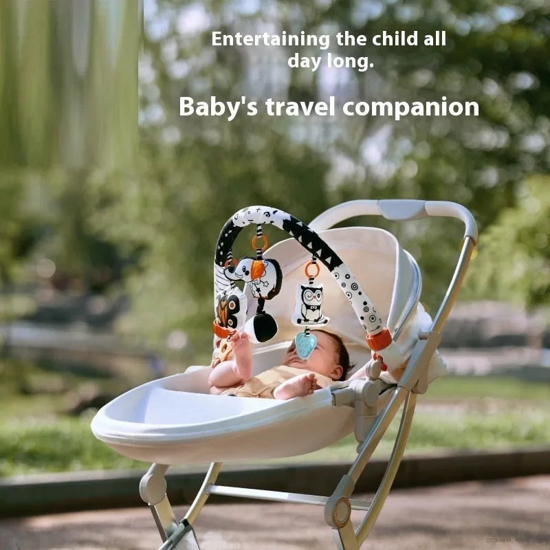 Baby lathe clip hanging plush toy in black and white with pull vibration teether, attached to a cot