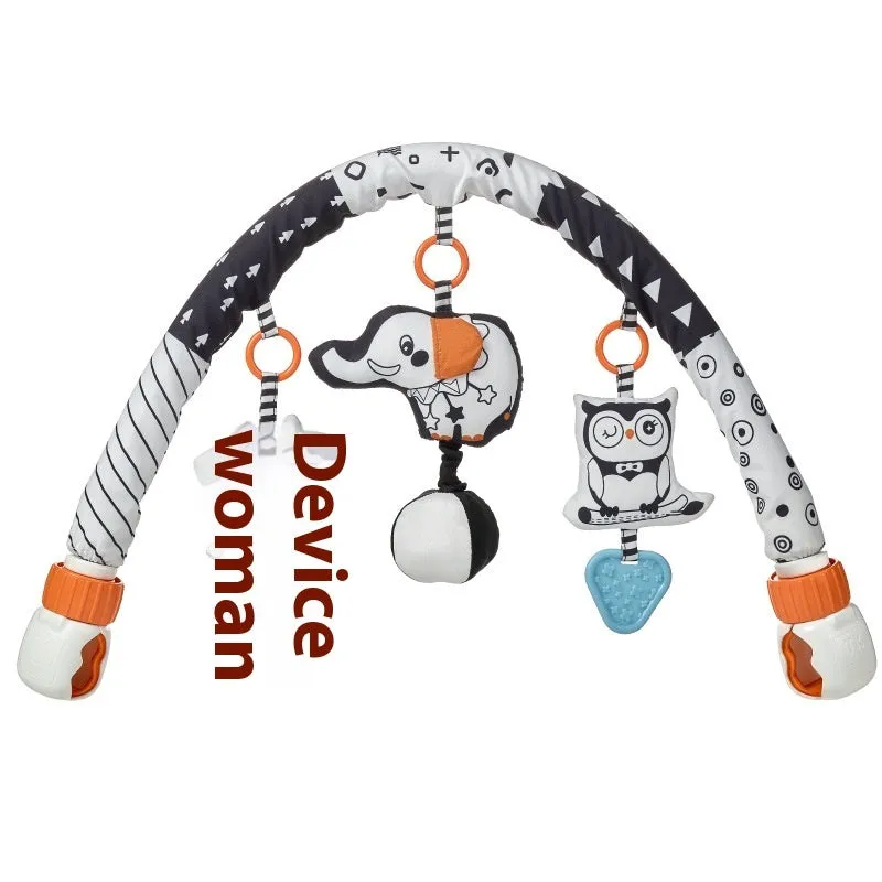 Baby lathe clip hanging plush toy in black and white with pull vibration teether, attached to a cot