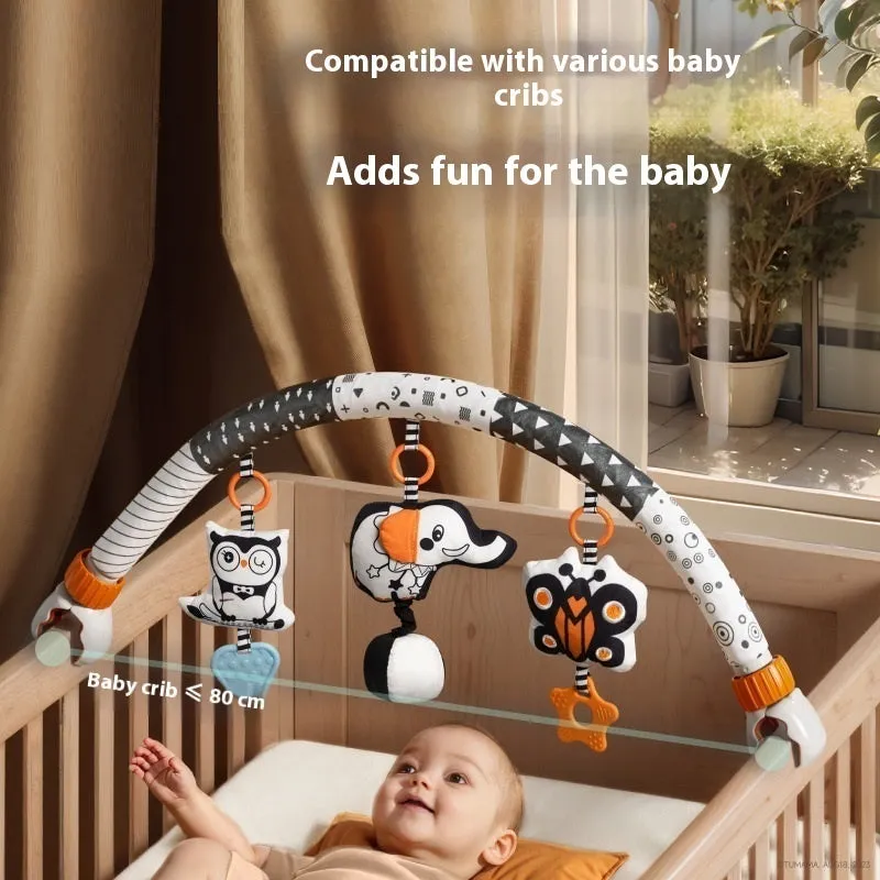 Baby lathe clip hanging plush toy in black and white with pull vibration teether, attached to a cot