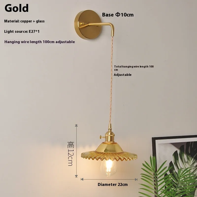 Retro brass lotus wall lamp with glass shade mounted on a beige wall, showcasing its copper arm and layered design.