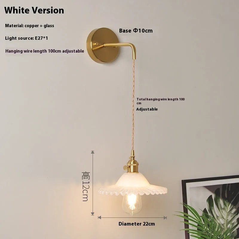 Retro brass lotus wall lamp with glass shade mounted on a beige wall, showcasing its copper arm and layered design.