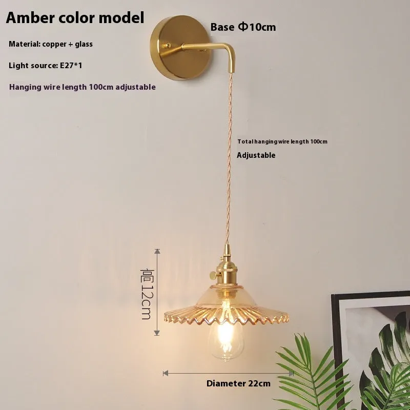 Retro brass lotus wall lamp with glass shade mounted on a beige wall, showcasing its copper arm and layered design.