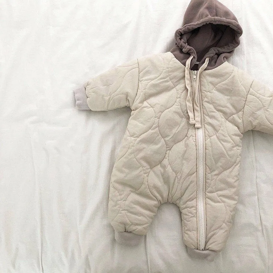 Baby padded quilted cotton kumpsuit in beige with attached hat and long sleeves, shown on a white background