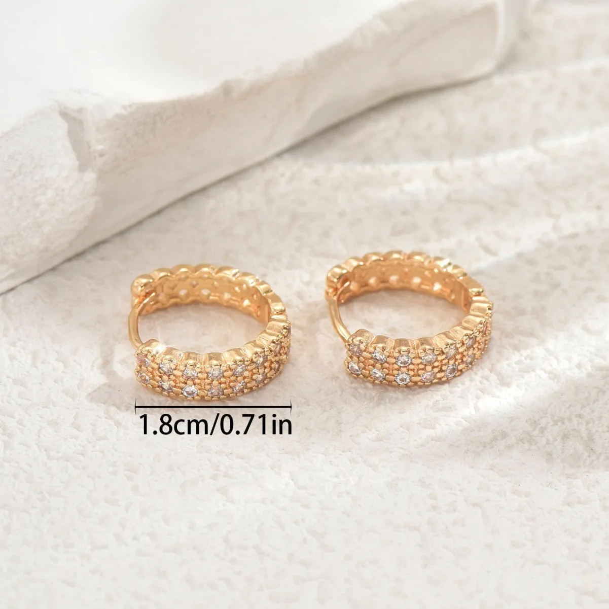 A pair of copper geometry pattern ear studs with round, dot and ring designs in colour DE20288.