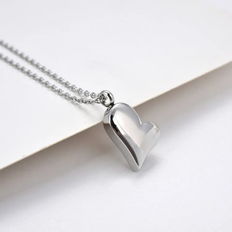 Silver curved peach heart stainless steel pendant necklace on display