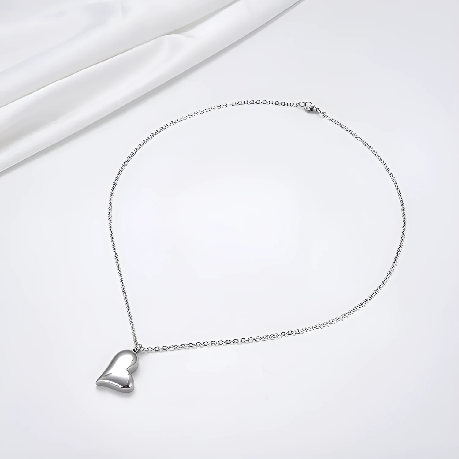 Silver curved peach heart stainless steel pendant necklace on display