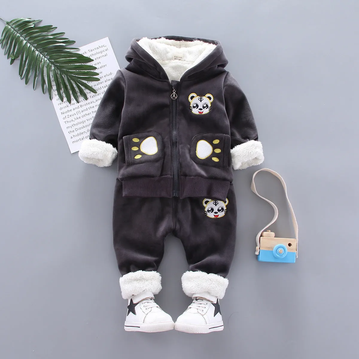 Child wearing a long sleeve golden mink fleece pyjama set with cartoon animal pattern in navy blue for winter