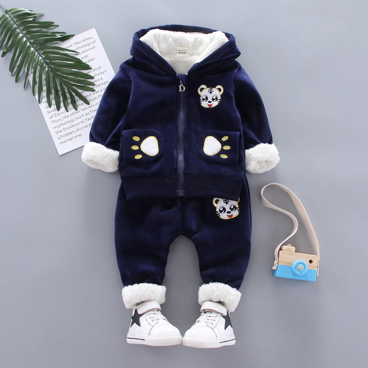 Child wearing a long sleeve golden mink fleece pyjama set with cartoon animal pattern in navy blue for winter