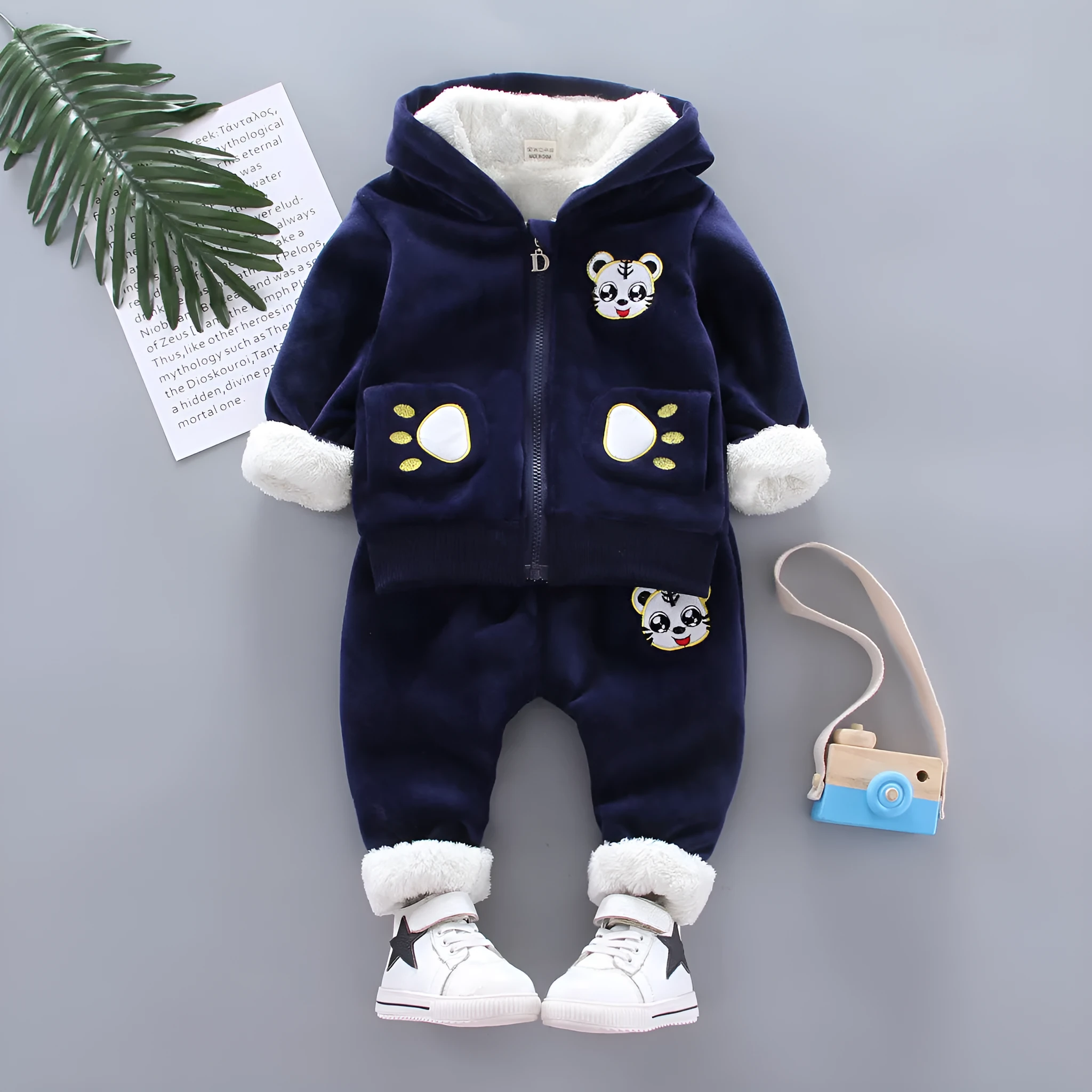 Child wearing a long sleeve golden mink fleece pyjama set with cartoon animal pattern in navy blue for winter