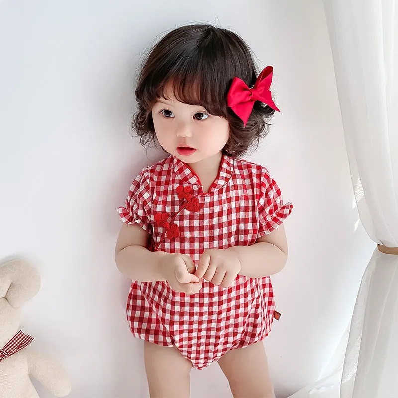 Red cotton baby cheongsam jumpsuit with short sleeves and triangle climbing design on white background