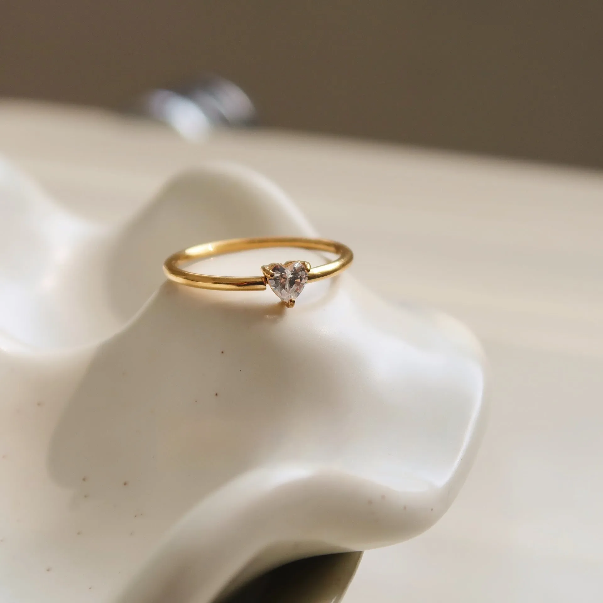 Golden love heart stainless steel ring showing heart shape design on female hand