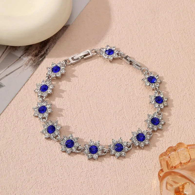Electroplated zinc alloy flower bracelet with coloured crystals in gold or silver finish.