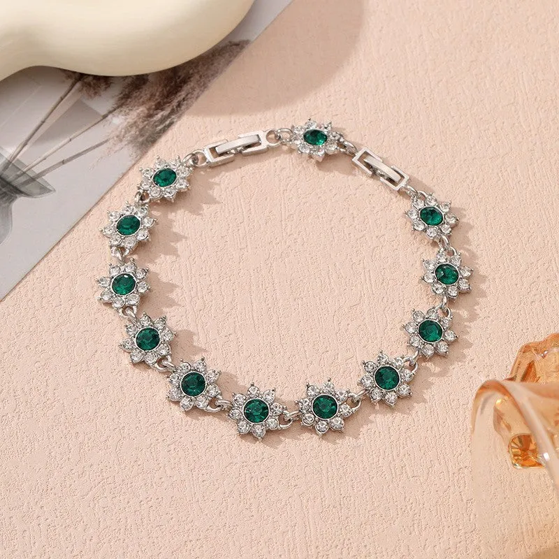 Electroplated zinc alloy flower bracelet with coloured crystals in gold or silver finish.
