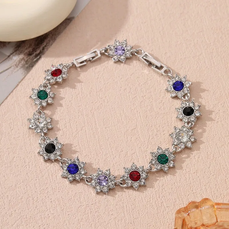 Electroplated zinc alloy flower bracelet with coloured crystals in gold or silver finish.