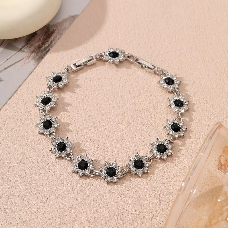 Electroplated zinc alloy flower bracelet with coloured crystals in gold or silver finish.