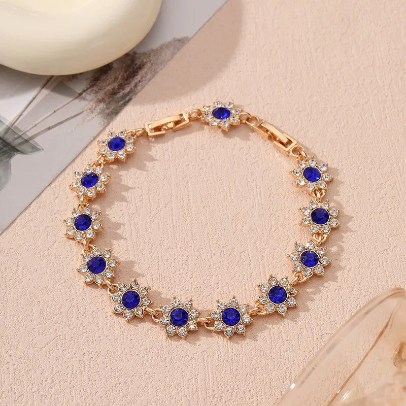 Electroplated zinc alloy flower bracelet with coloured crystals in gold or silver finish.