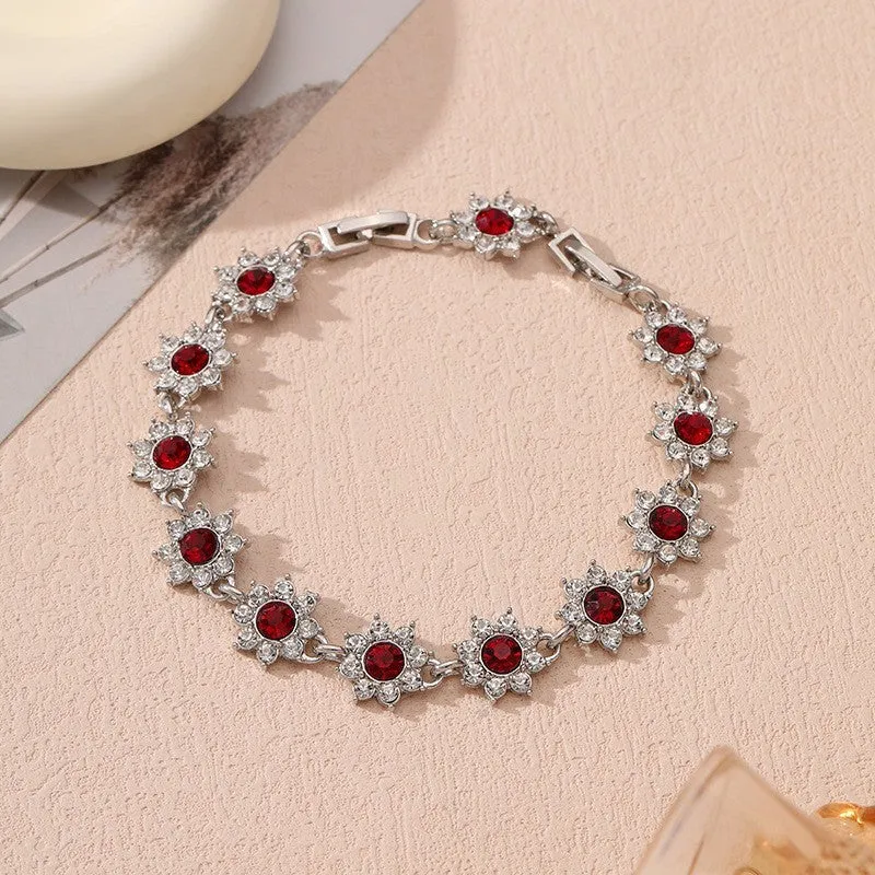 Electroplated zinc alloy flower bracelet with coloured crystals in gold or silver finish.