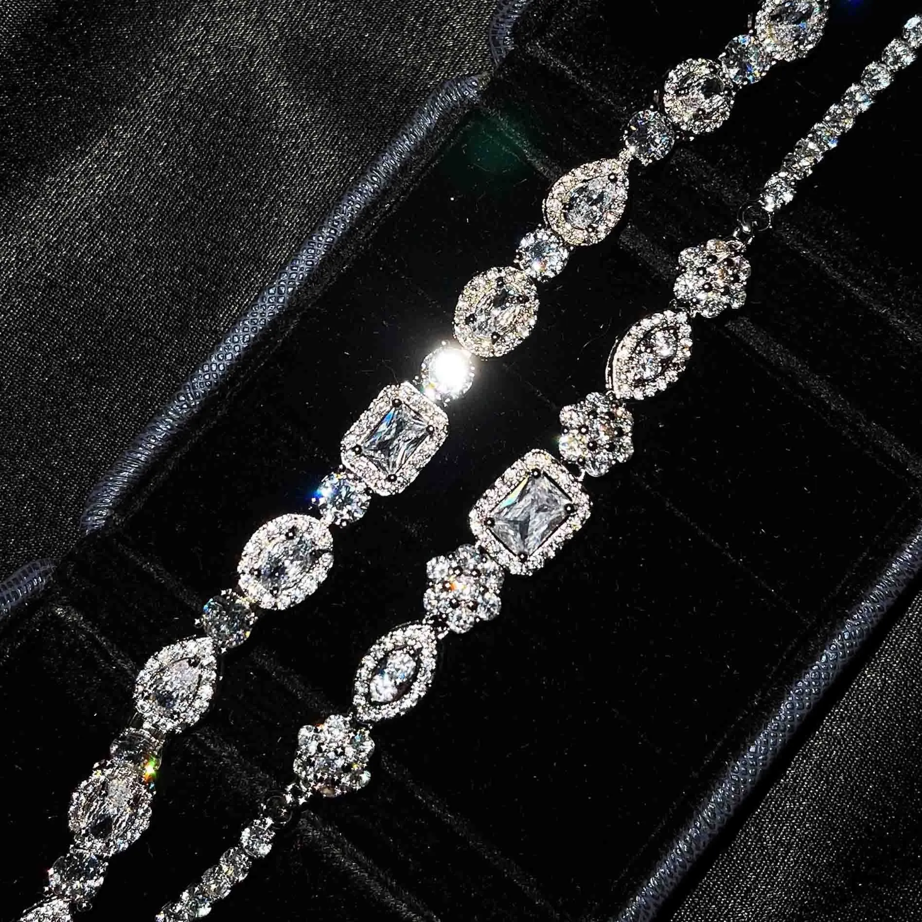 Women's geometric silver bracelet with inlaid white zircon stones on a wrist, showing adjustable clasp.