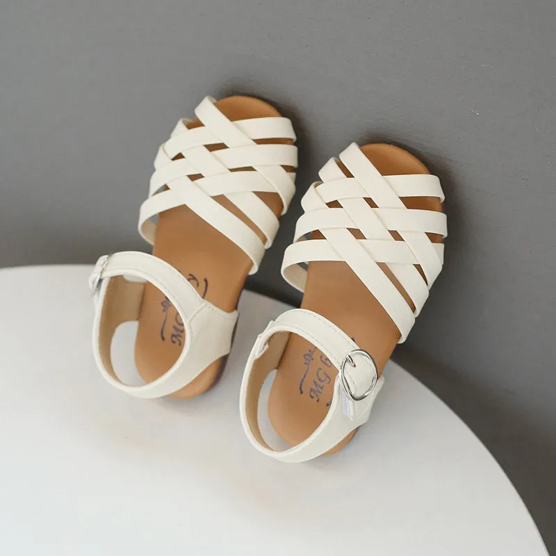 Kids buckle-toe soft sole woven sandals in white, black, and pink on a light background
