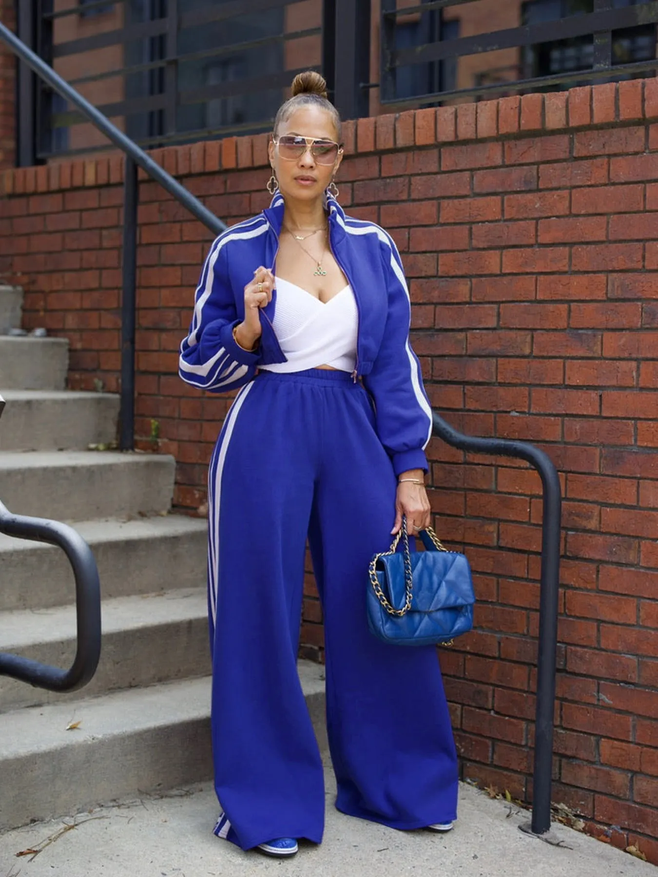 Grey striped two-piece sweater set with a zippered top and matching trousers on a model.