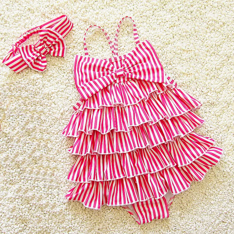 Navy style infant one-piece swimsuit with built-in steel support, pink colour with matching hair band, on a light background