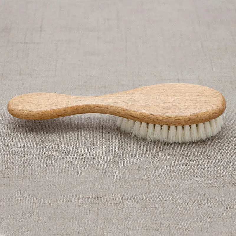 Beech wood baby shampoo brush with goat wool bristles in primary colour finish.