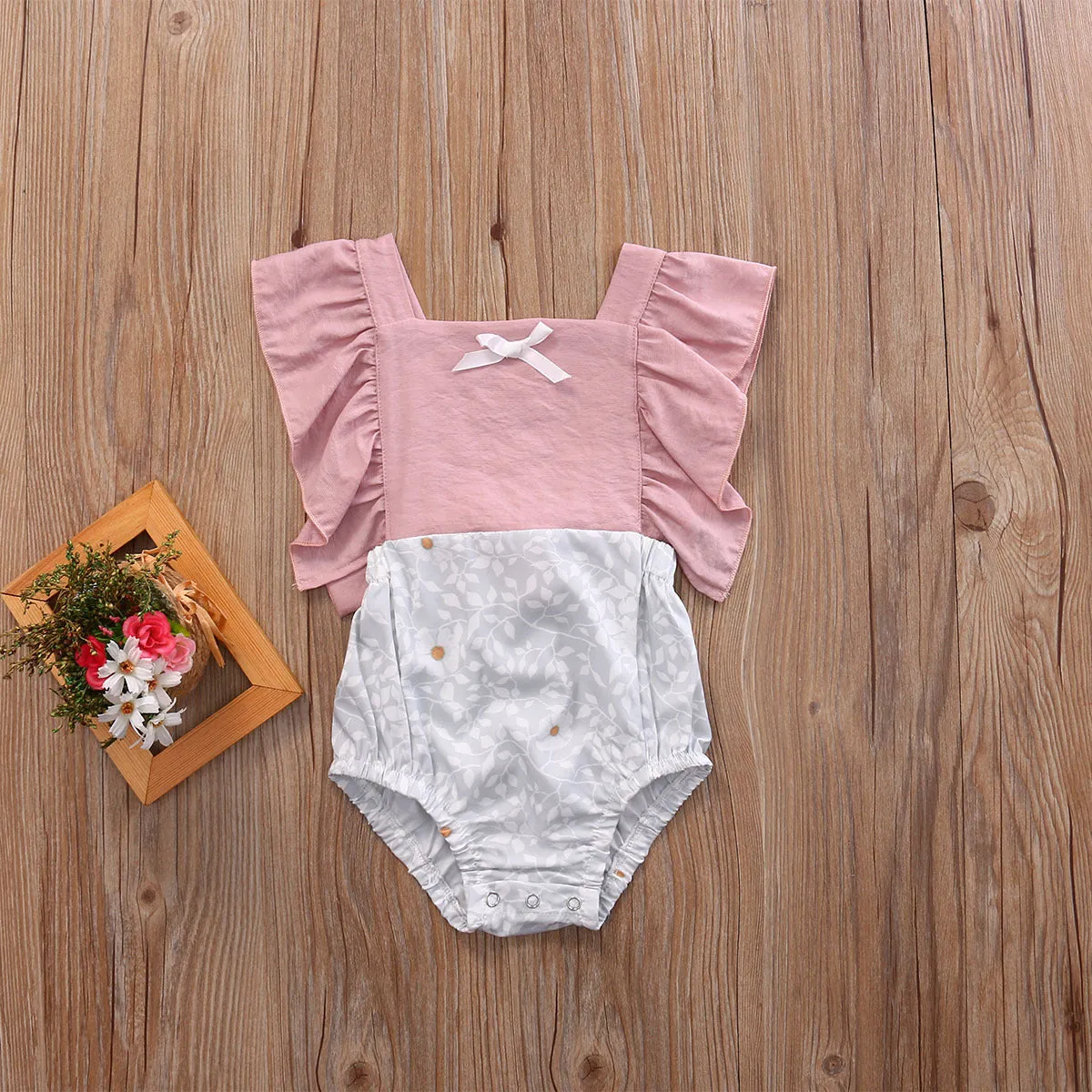 Camellia ruffles romper for baby girls with floral patchwork and back cross design in pink colour