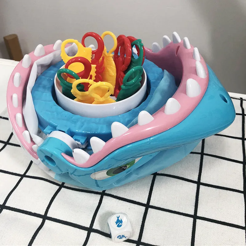 Great white shark tricky toy with small plastic fish inserted in its mouth on a tabletop