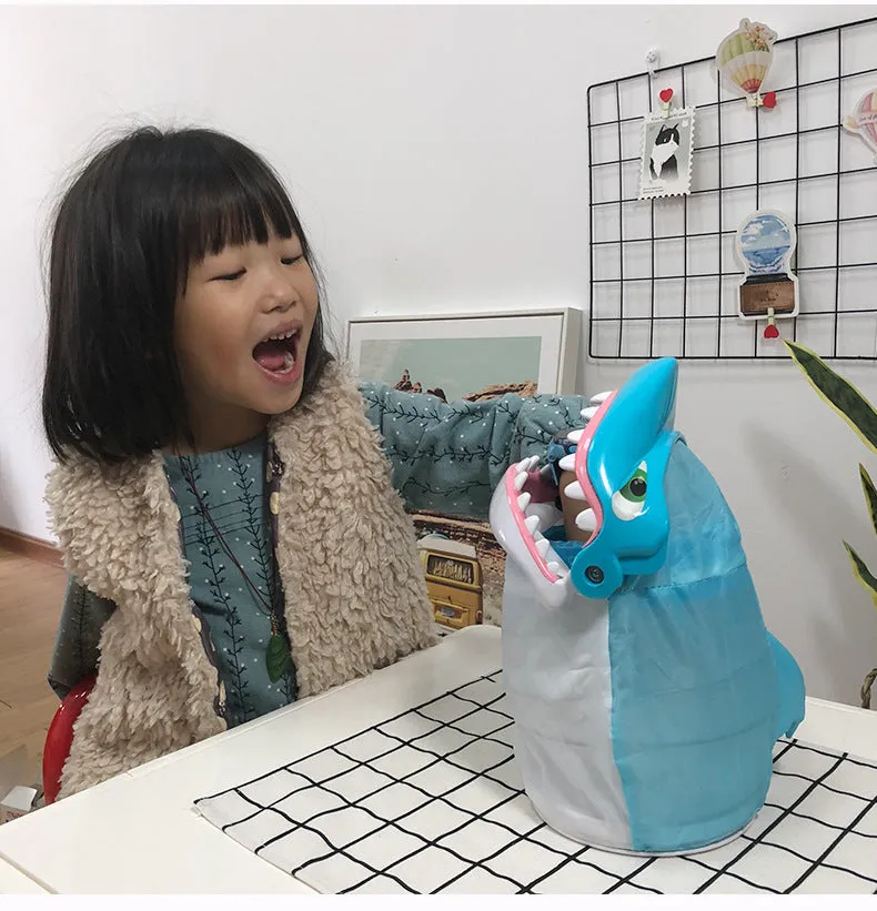 Great white shark tricky toy with small plastic fish inserted in its mouth on a tabletop