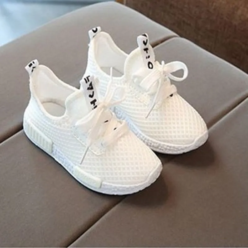 Mesh girls' primary school sneakers in white with rubber sole and front tie closure on a plain background