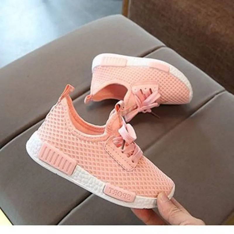 Mesh girls' primary school sneakers in white with rubber sole and front tie closure on a plain background