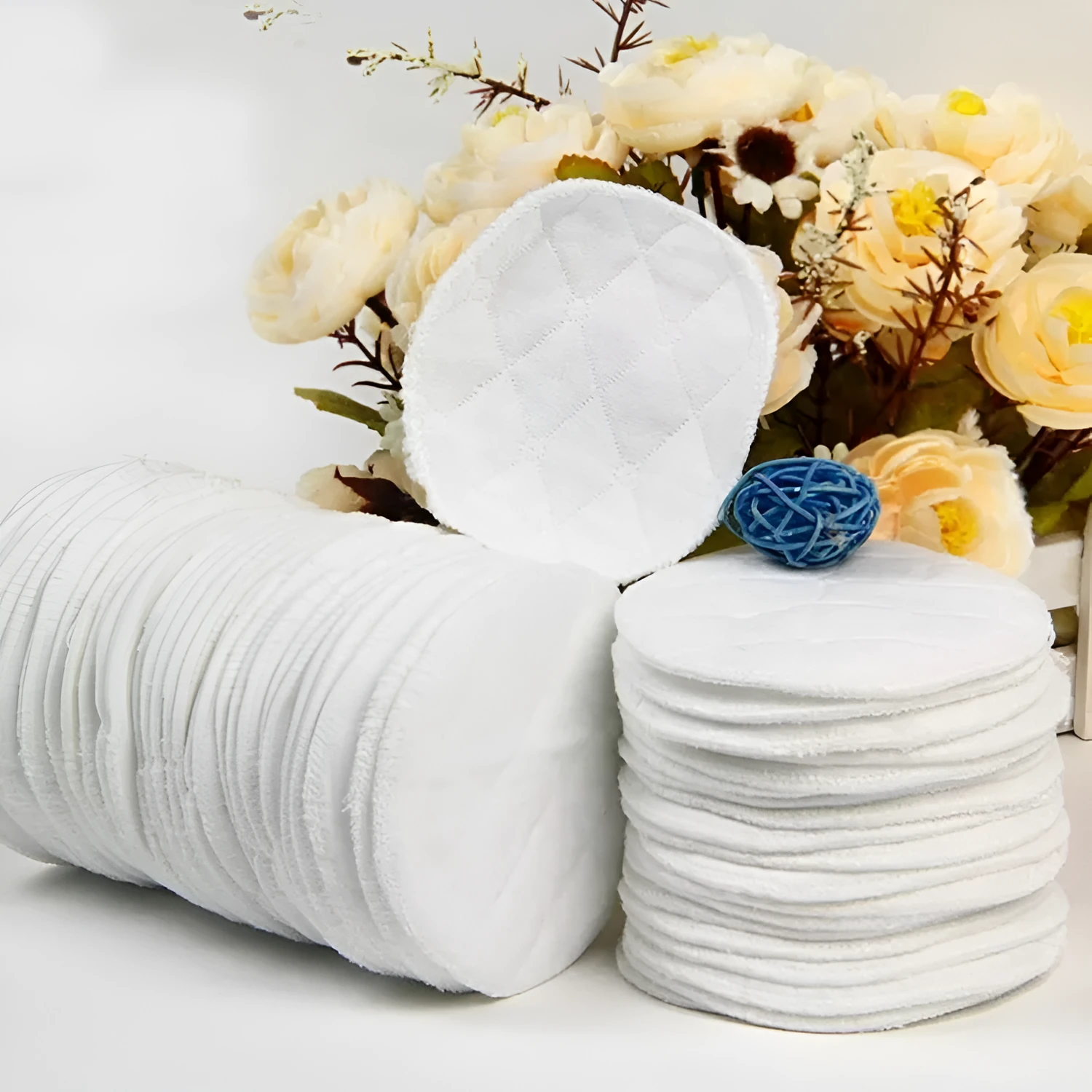 Pack of four white eco-cotton double-layer anti-galactorrhea nursing pads on a white background