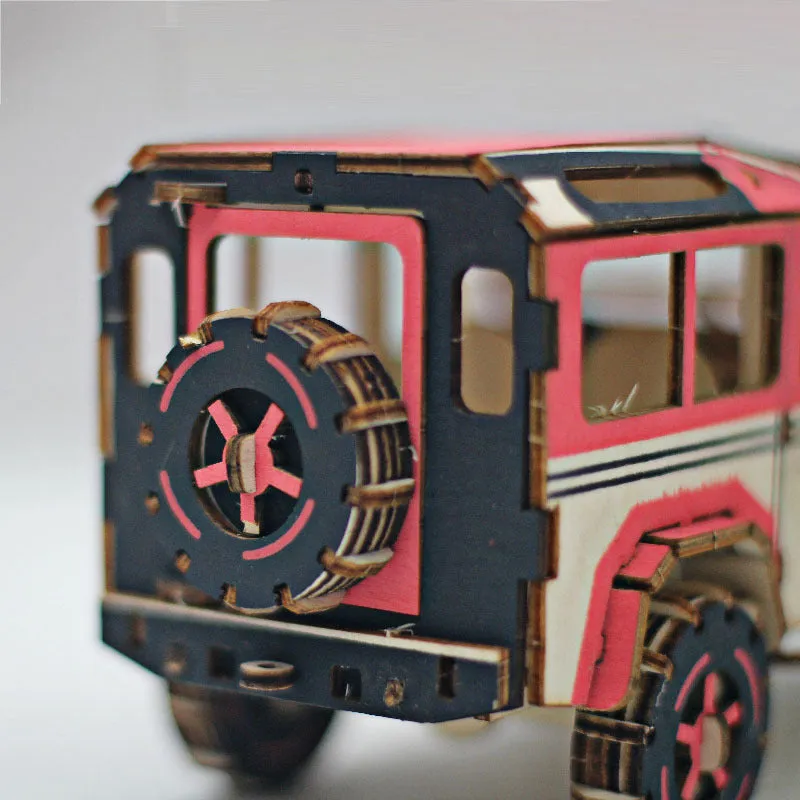3D wooden puzzle kit showing a Ferrari style model with interlocking pieces on a table