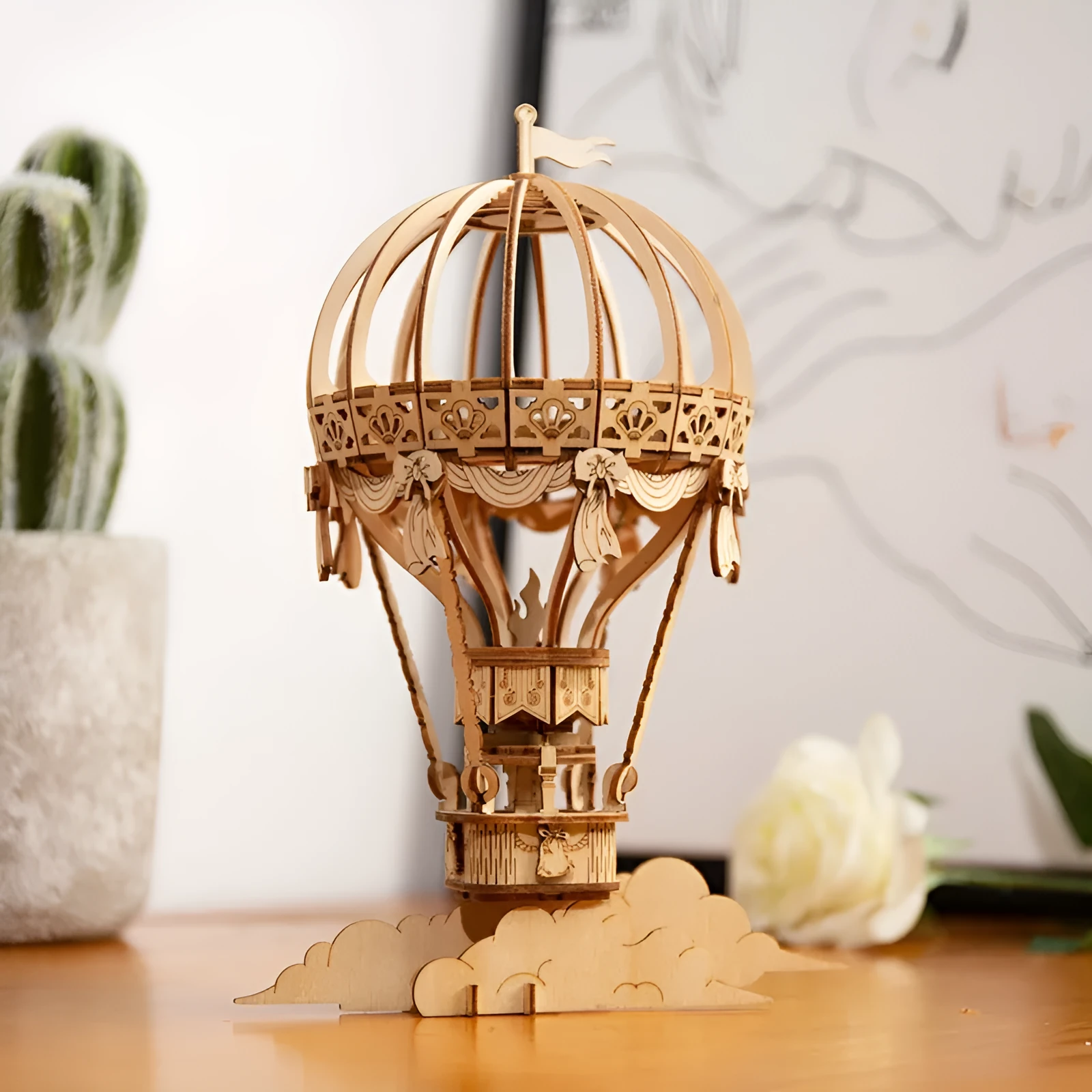 Wooden 3D puzzle model of a balloon assembled from pre-cut wood pieces on a light background