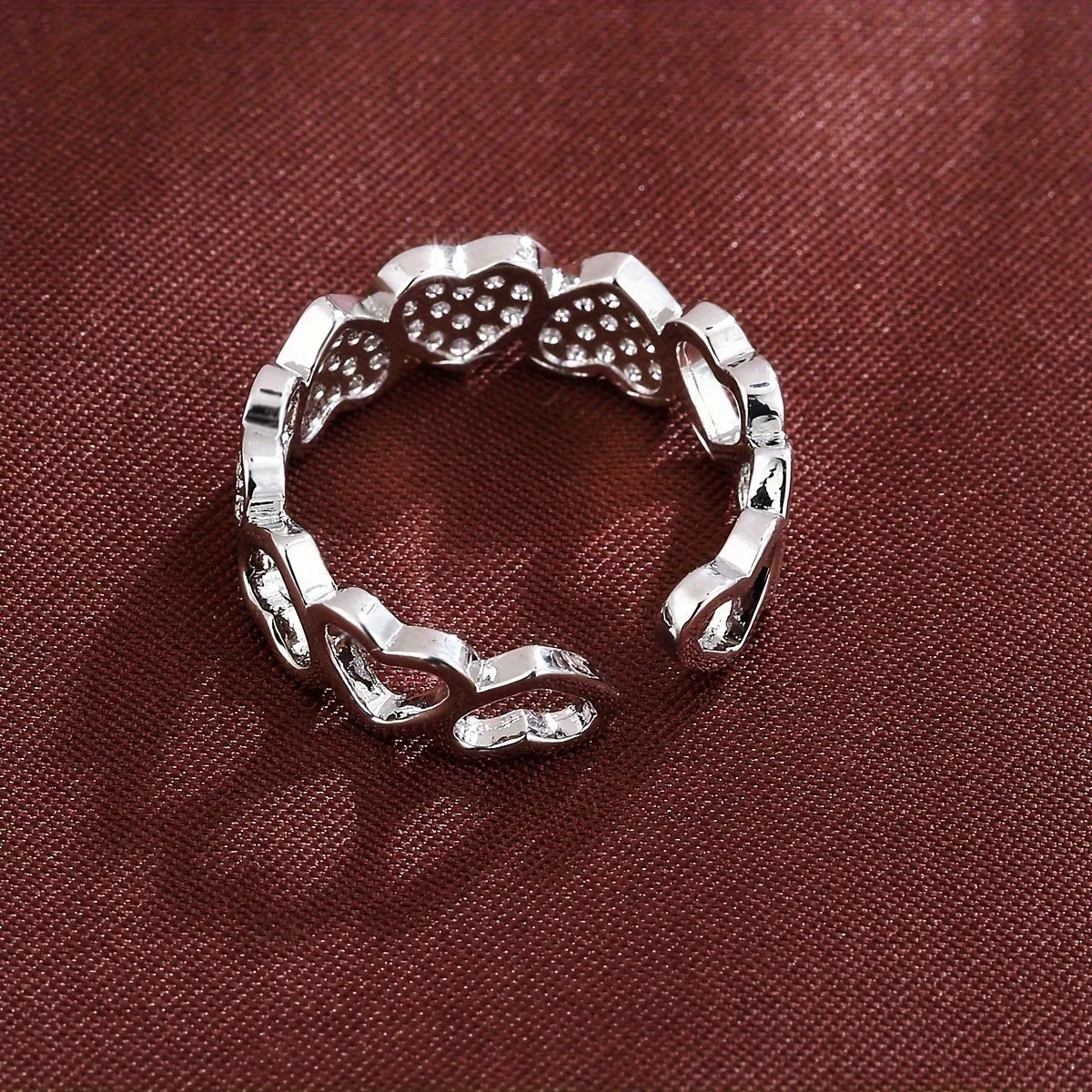 Geometric adjustable heart ring in gold plating, showing diamond-cut facets and open band design.