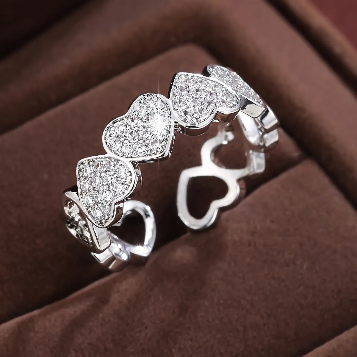 Geometric adjustable heart ring in gold plating, showing diamond-cut facets and open band design.