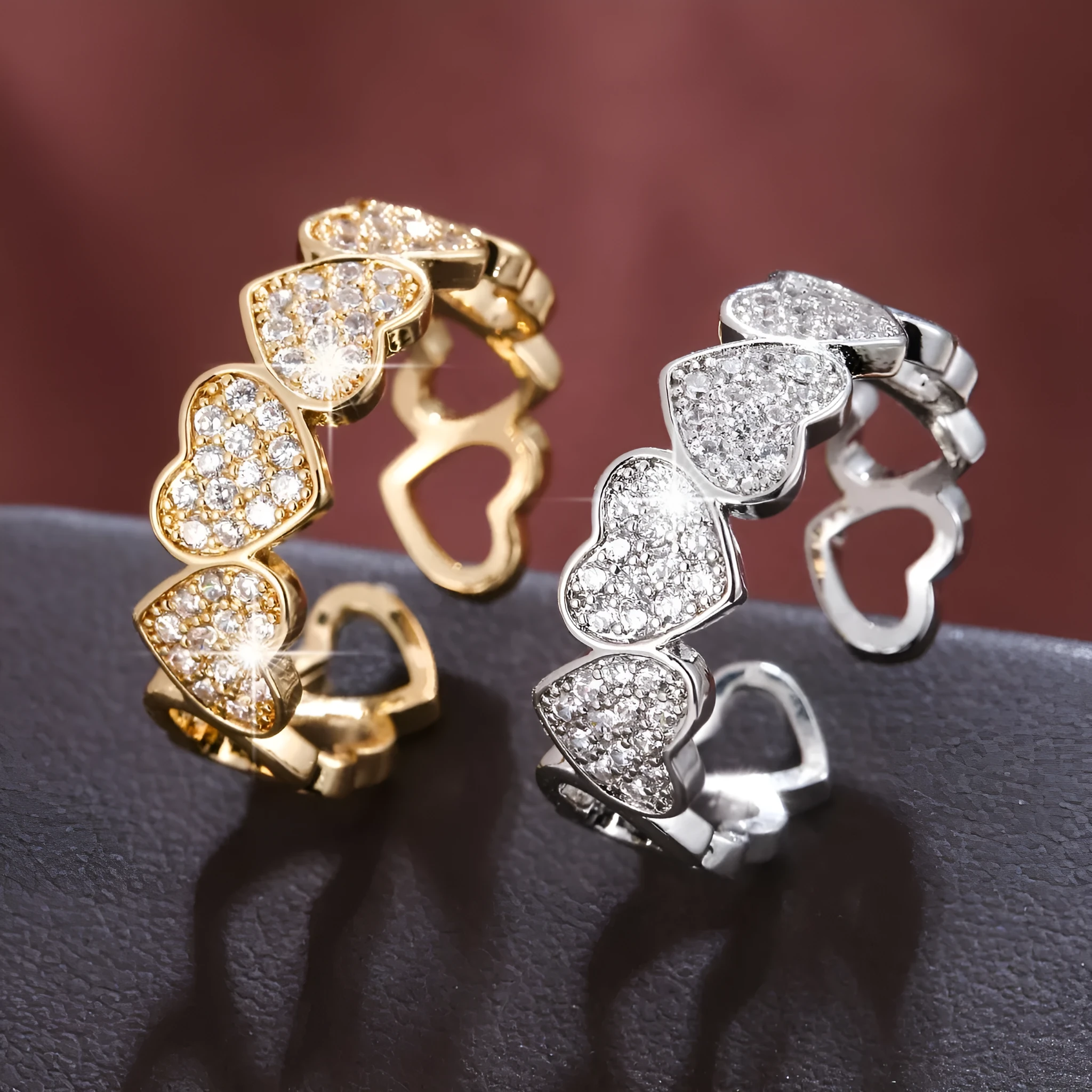 Geometric adjustable heart ring in gold plating, showing diamond-cut facets and open band design.