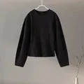 Women's black polar fleece suit set with long sleeve pleated top and wide leg trousers on a hanger.
