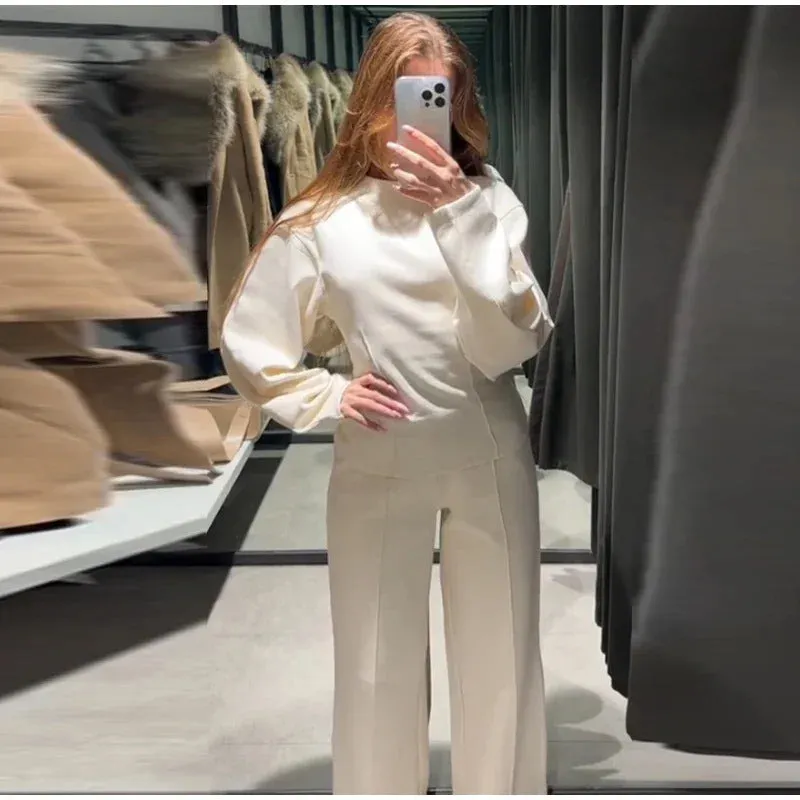 Women's black polar fleece suit set with long sleeve pleated top and wide leg trousers on a hanger.