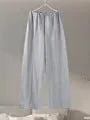 Women's black polar fleece suit set with long sleeve pleated top and wide leg trousers on a hanger.