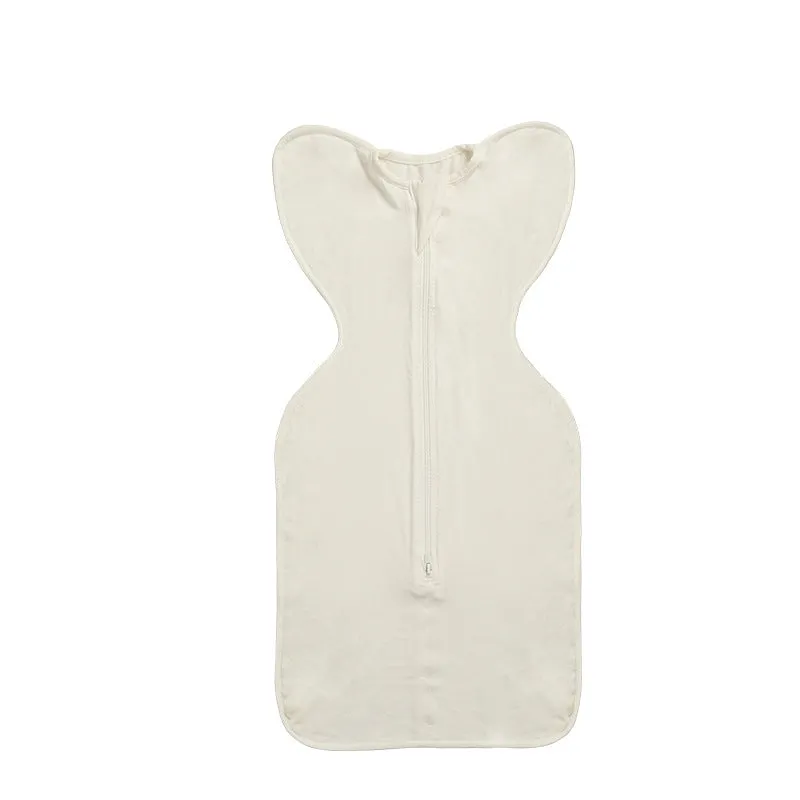 Newborn baby swaddled in bamboo fibre gauze sleeping bag with matching beanie in solid colour