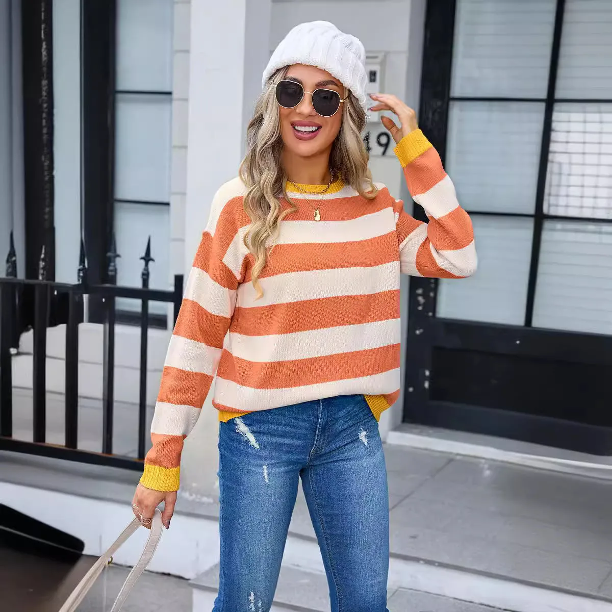 Women's loose blue striped acrylic knit sweater with long sleeves on a hanger.