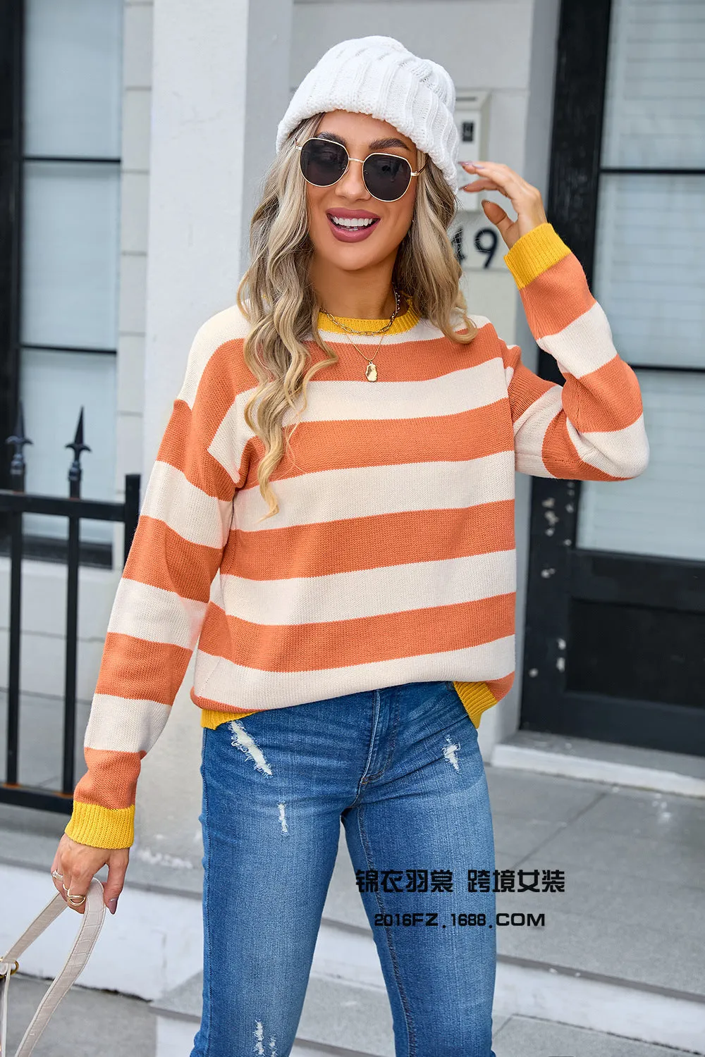 Women's loose blue striped acrylic knit sweater with long sleeves on a hanger.