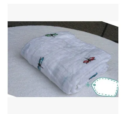 Cotton gauze baby blanket 120x120cm in balloon elephant style folded on a light background