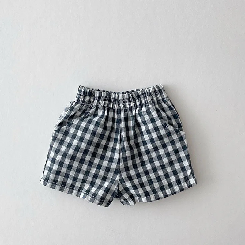 Baby loose thin cotton and linen shorts in black with elastic waist, side view on white background