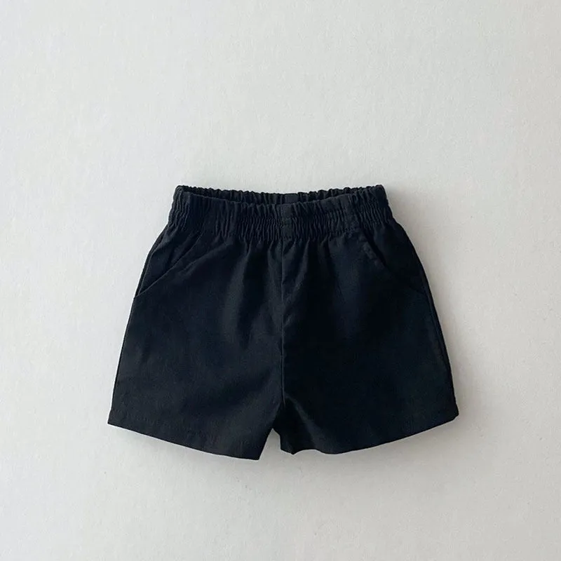 Baby loose thin cotton and linen shorts in black with elastic waist, side view on white background